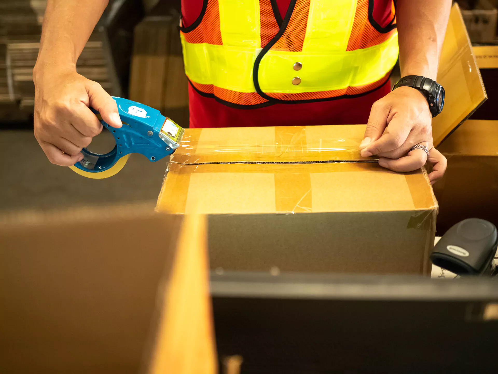 Person putting tape on a cardboard box