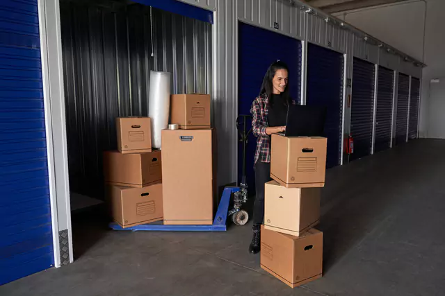 Woman taking notes in a clipboard near cardboard boxes